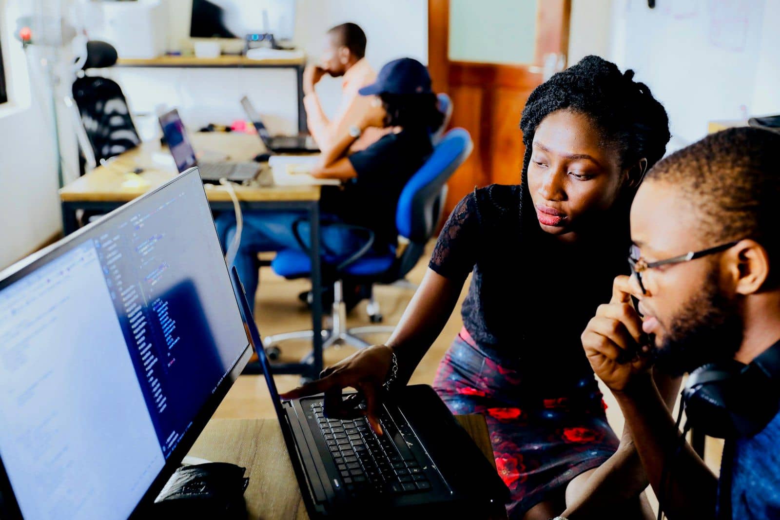A small team collaborating around a laptop in an office